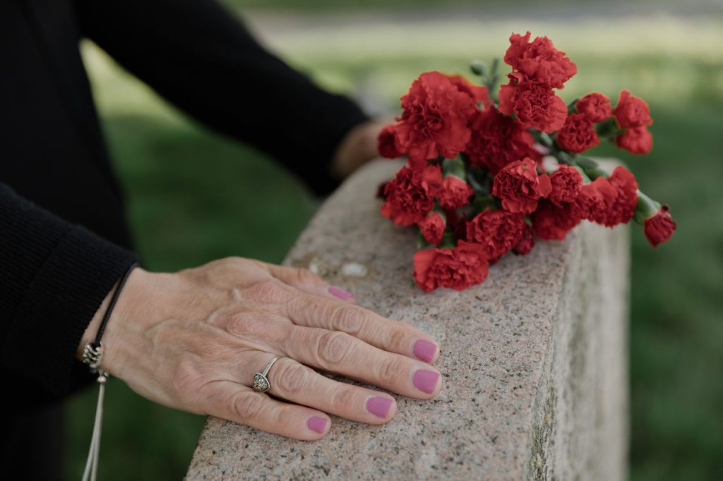 woman standing at a grave